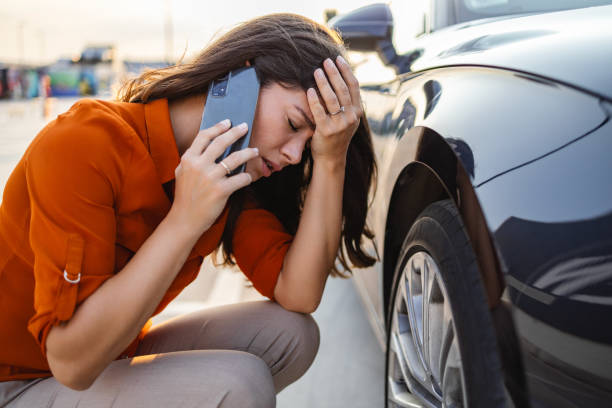 una mujer triste se sienta en la rueda pinchada de un automóvil. servicio de neumáticos y servicio de coche de guardia. cursos para conductores y mecánicos de automóviles. bomba para ruedas de coche. deslumbramiento solar - vehicle breakdown car stranded women fotografías e imágenes de stock