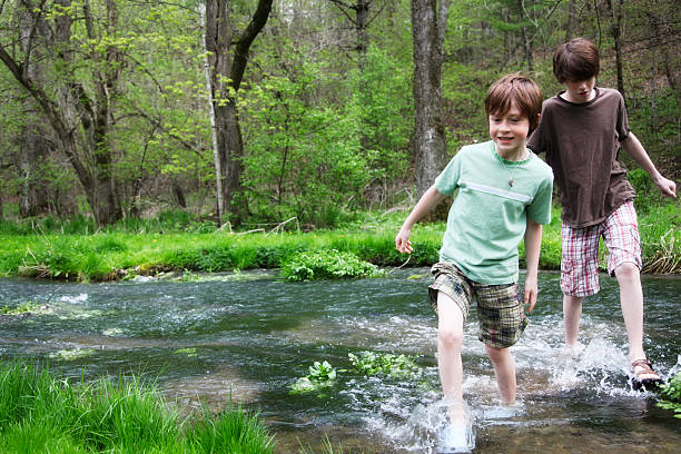 ragazzini a piedi si increspa in legno stream- green park - parker brothers foto e immagini stock