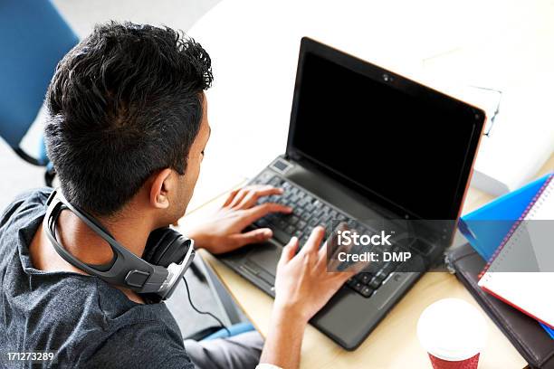 Indio Joven Estudiante Usando Computadora Portátil Foto de stock y más banco de imágenes de Hindú - Hindú, Hombres, Ordenador portátil