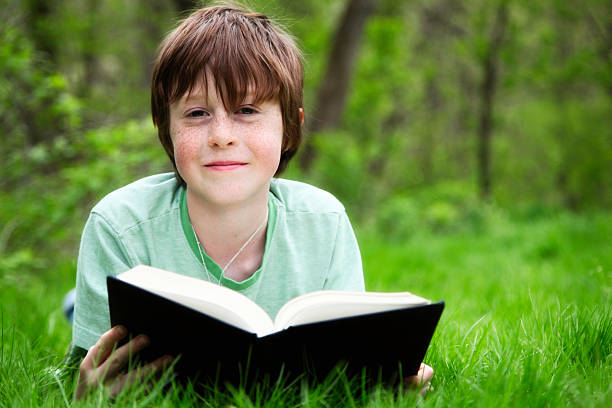 istock Happy Child Reading A Book Outside in Nature 171273299