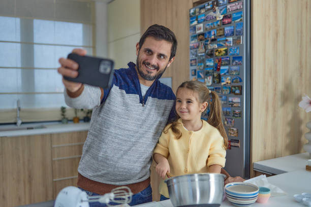 istock Young girl stands at the kitchen table making cakes with her father 1712734739