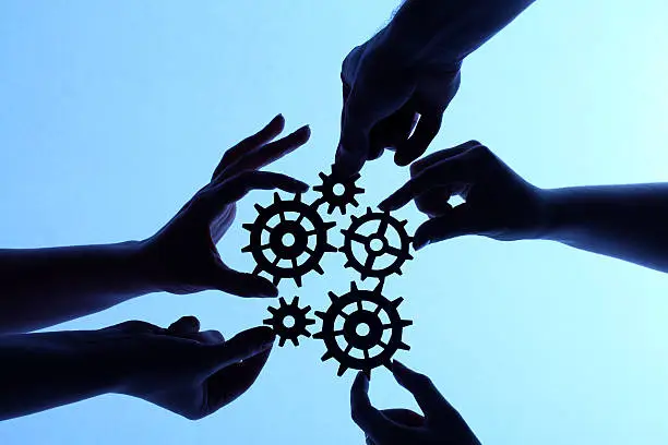 Photo of Silhouette of hands holding cogs and gears