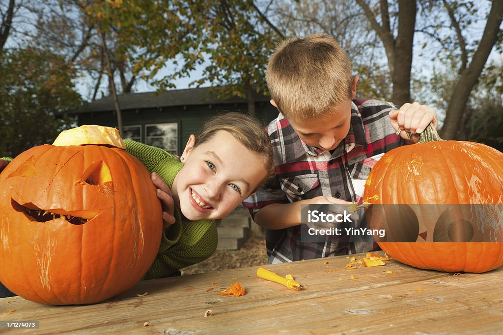 Нравится Счастливые дети вырезать Хэллоуина Pumpkins вместе открытый осенью - Стоковые фото Предподростковый возраст роялти-фри