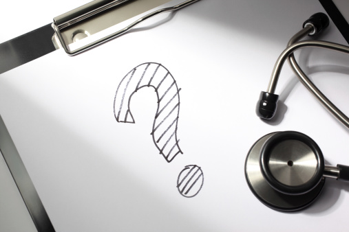 Healthcare concept. A question mark is drawn on a doctor's clipboard with stethoscope.