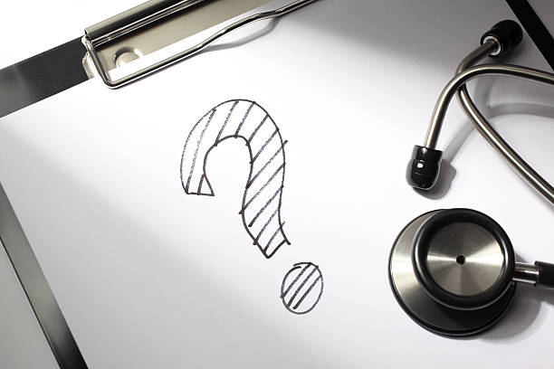 Medical Question Healthcare concept. A question mark is drawn on a doctor's clipboard with stethoscope. health symbols/metaphors stock pictures, royalty-free photos & images