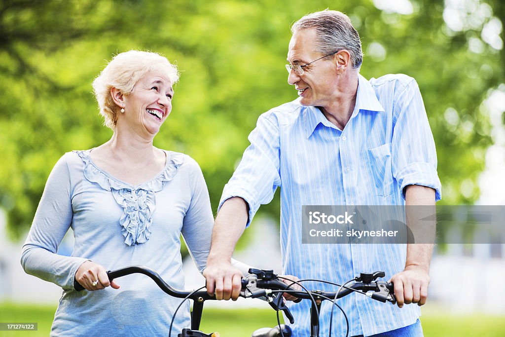 Alegre casal andando de bicicletas no parque. - Foto de stock de Adulto royalty-free