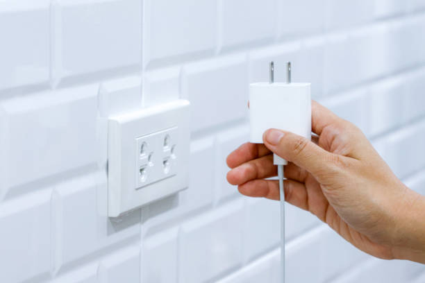 istock Hand holding preparing to connect USB type c adaptor plug into electrical wall outlet, Electrical equipment, Connect the charger connector to household power. Energy saving concept. 1712741279
