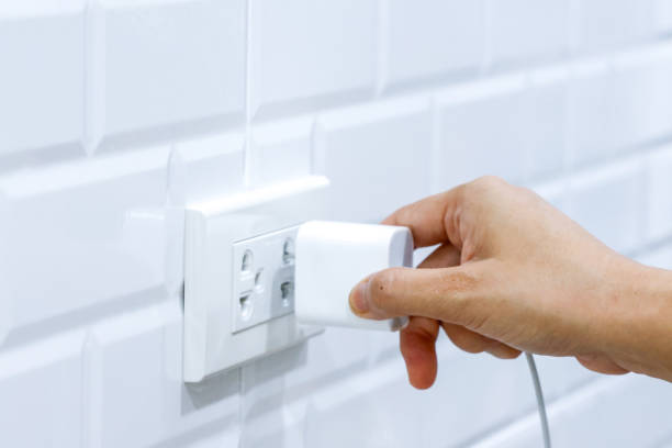 istock Hand holding to connect USB type c adaptor plug into electrical wall outlet, Electrical equipment, Connect the charger connector to household power. Energy saving concept. 1712741794