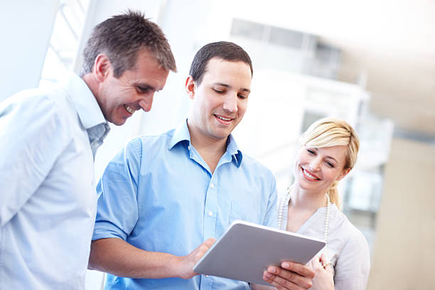istock Two men and a woman with a digital tablet 171274384