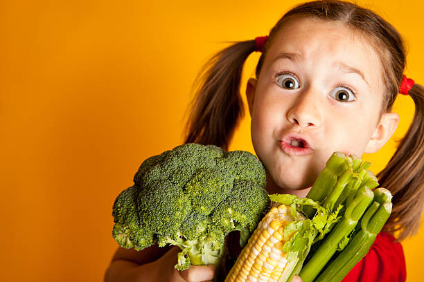 istock Young Girl Holding Broccoli, Corn, and Celery, With Copy Space 171274676