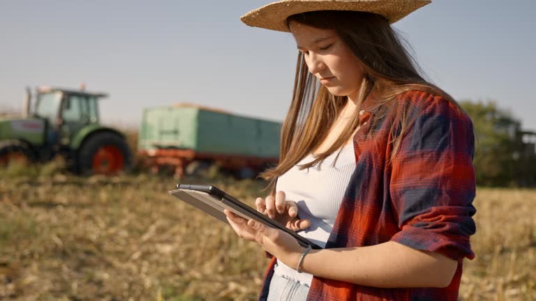 SLO MO Tilt Up Shot of Beautiful Agronomist in Sunhat Using Digital Table on Harvested Corn Field during Sunny Day