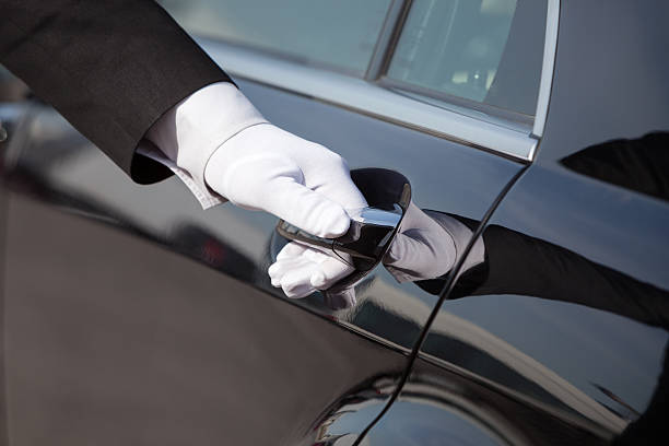 Chauffeur opening / closing luxury car door The white gloved hand of a uniformed chauffeur / doorman opening / closing a luxury car door. door attendant photos stock pictures, royalty-free photos & images