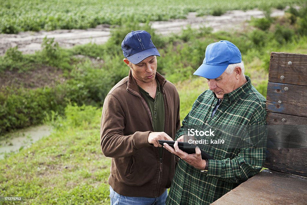 Gli agricoltori con digital tablet in fattoria di patate - Foto stock royalty-free di Agricoltore