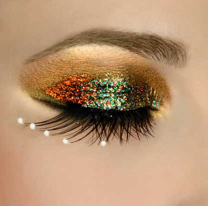 young woman eye with glitter makeup,eye closed.
