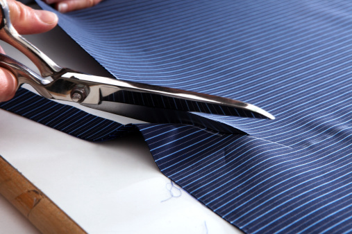 Italian tailor cutting the cloth for a hand-made shirt.Other images in: