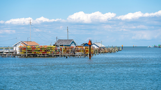 Colorful crab pots stacked on docks along the channel on Tangier Island, Virginia, USA. Crabbing is the main industry on Tangier Island but geologic subsidence and sea level rise may submerge the island by 2050.