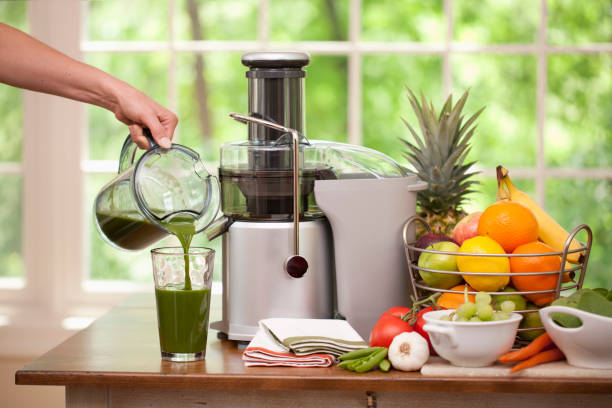 pouring a glass of  fresh organic green juice - 榨汁機 個照片及圖片檔