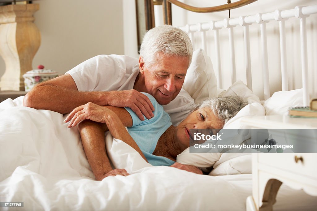 Senior Man Tries To Be Affectionate Towards Wife In Bed Senior Man Tries To Be Affectionate Towards Wife In Bed. Sex and Reproduction Stock Photo