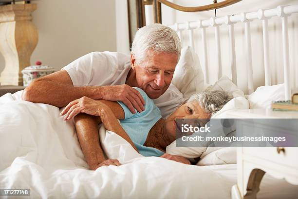 Senior Man Tries To Be Affectionate Towards Wife In Bed Stock Photo - Download Image Now