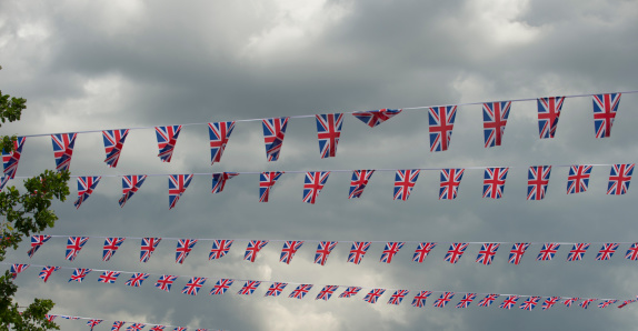 Union Jack bunting, flags flying against stormy skies