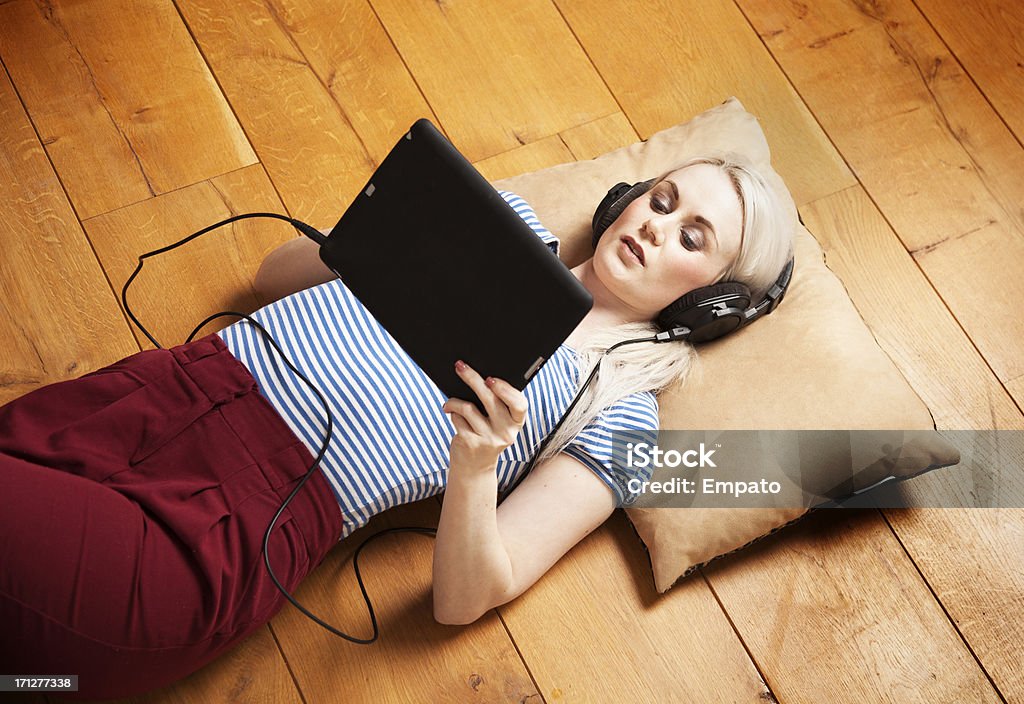 Mädchen Musik hören auf elektronische tablet. - Lizenzfrei Holzboden Stock-Foto