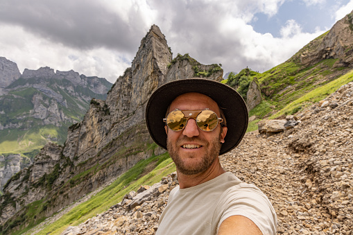 Taking selfies on vacation wile hiking in nature, Swiss Alps