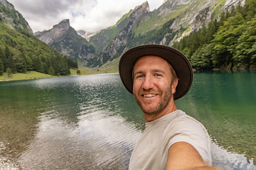 Man on a hike takes a selfie in nature