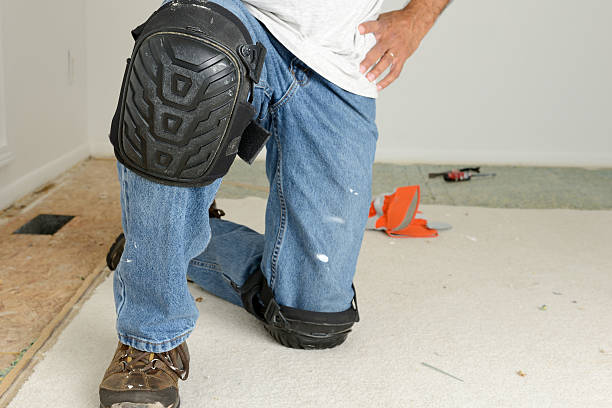 Home Improvement: Kneeling Worker's Legs With Kneepads stock photo