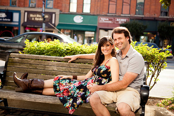 Happy Young Couple Sitting on Bench Downtown