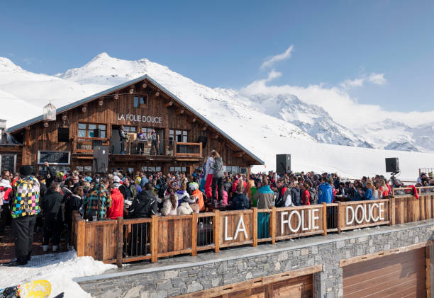 After Skiing in France "Val Thorens, France - March 9, 2012: Spectators watching musicians perform on a balcony stage at La Folie Douce restaurant and bar at the ski resort of Val Thorens in the Three Valleys." apres ski stock pictures, royalty-free photos & images