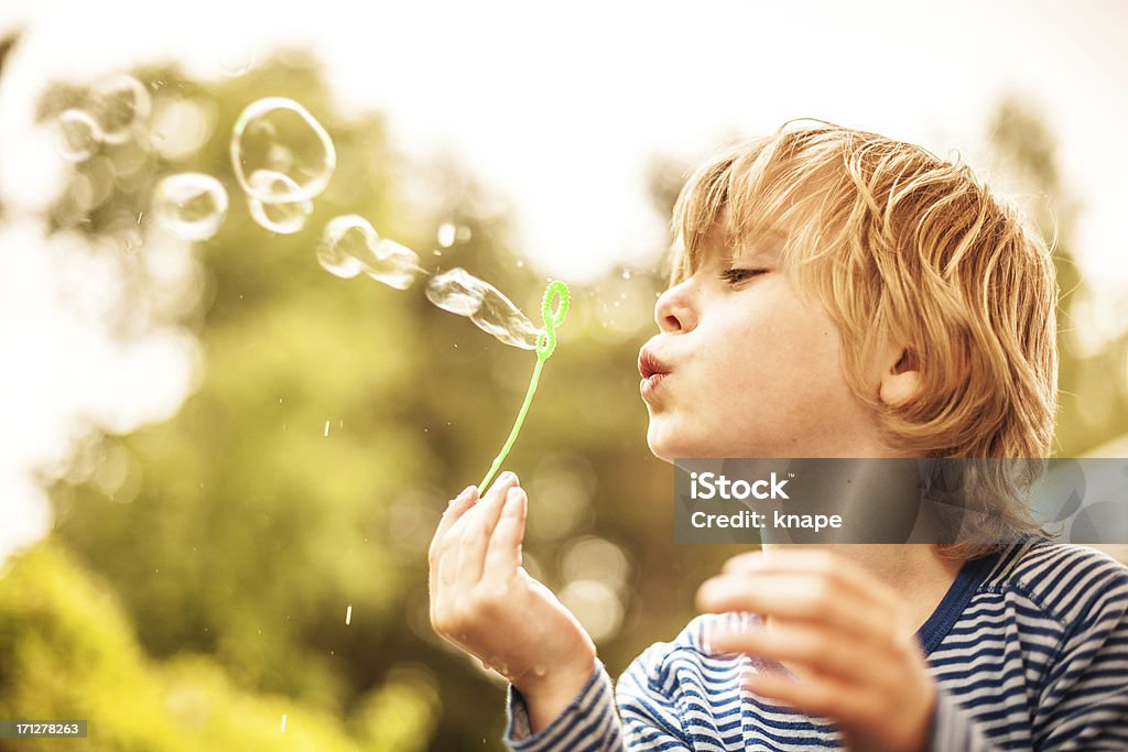 Mignon petit garçon à l'extérieur des bulles de soufflage - Photo de Enfant libre de droits