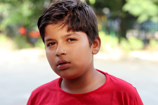 Close-up portrait of elementary age boy standing portrait outdoors in the nature during day time.