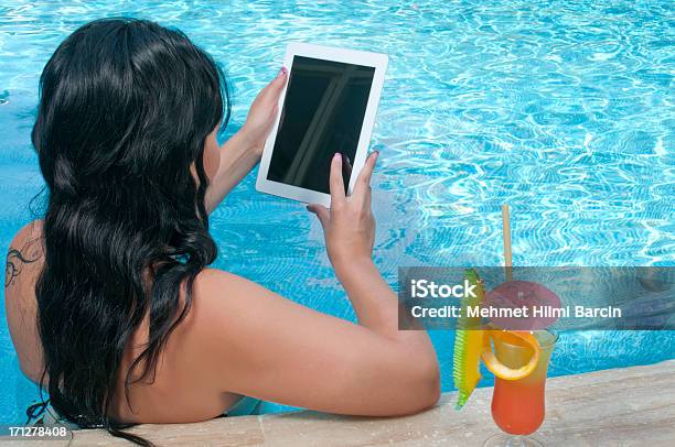 Photo libre de droit de Jeune Femme À Laide De Tablette Numérique Au Bord De La Piscine banque d'images et plus d'images libres de droit de Femmes