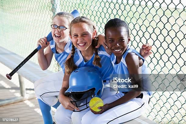 Niñas De Softball Equipo De Estar En El Banquillo De Campo De Béisbol Foto de stock y más banco de imágenes de Niño