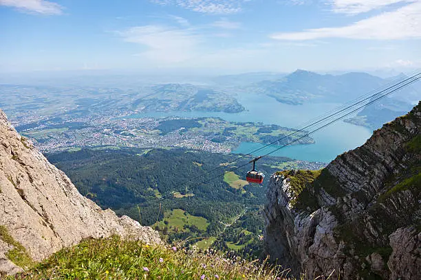 This overhead cable car brings passengers to the top of Mount Pilatus in the central Swiss Alps. In the background the city of Lucerne and the lake called Vierwaldstättersee are visible.