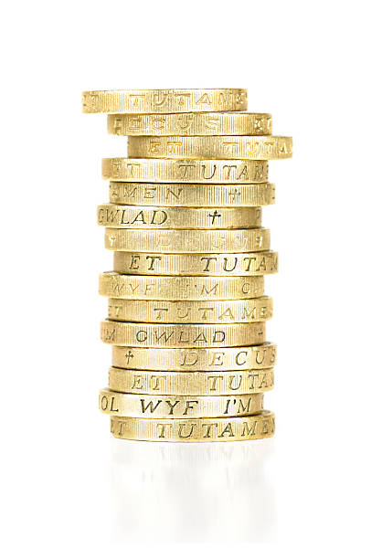 pila di monete d'oro e una libbra - one pound coin coin currency british culture foto e immagini stock