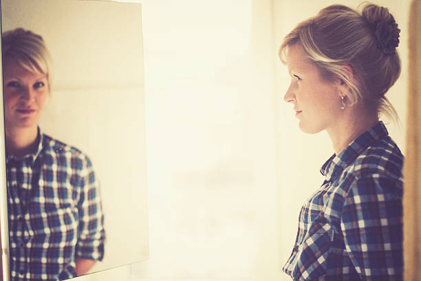 My Reflection and me Mirror mirror on the wall....Pretty blonde woman and her reflection. hochsteckfrisur stock pictures, royalty-free photos & images