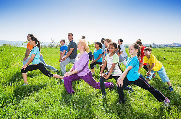 istock Group of people doing stretching exercises in field. 171280069