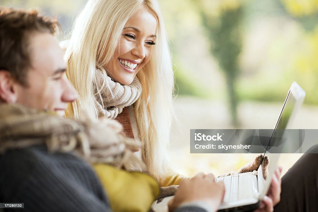 Belo Casal sentado no parque, usando um computador portátil. - Royalty-free Adulto Foto de stock