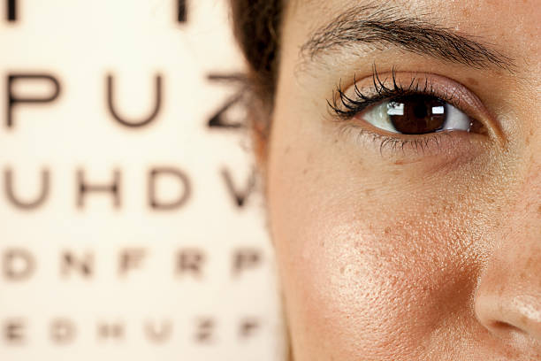 Woman's eye close-up with an eye test in the background stock photo