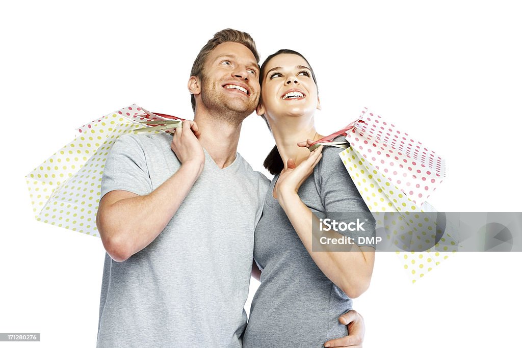 Coppia sorridente con borse guardando copyspace - Foto stock royalty-free di Felicità