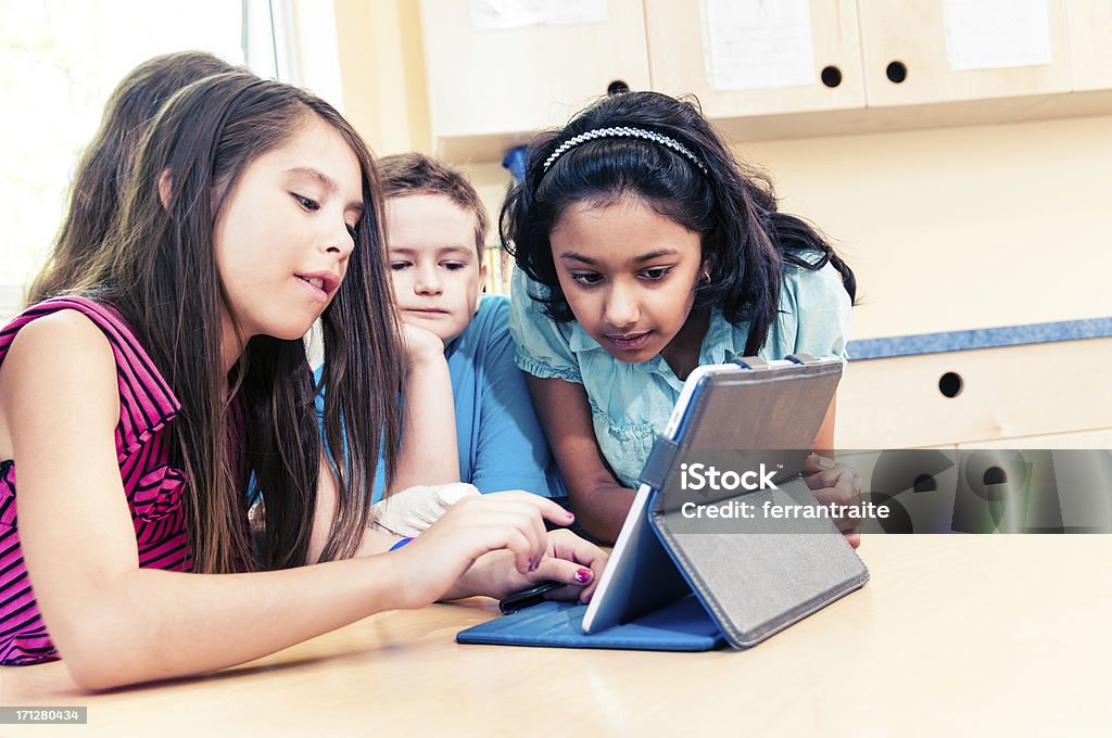 School Children using Tablet PC Primary school pupils using Tablet PC at school. Classroom Stock Photo