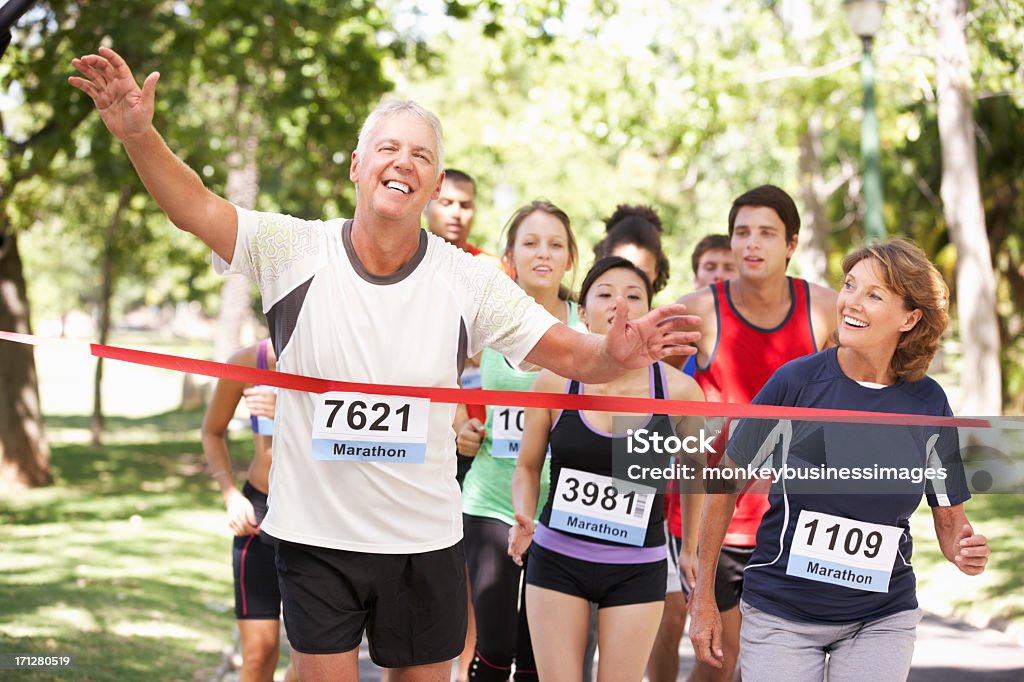 Male Athlete Winning Marathon Race Male Athlete Winning Marathon Race Cossing Finishing Line Finish Line Stock Photo