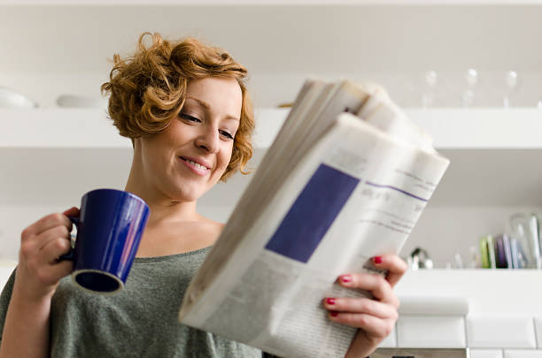 jovem mulher com café e jornal - reading newspaper 30s adult - fotografias e filmes do acervo