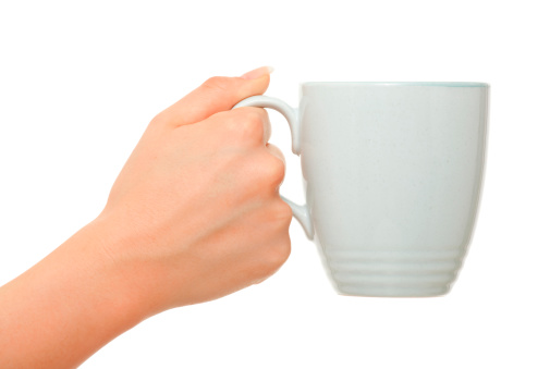 Female hand holding coffee mug on white