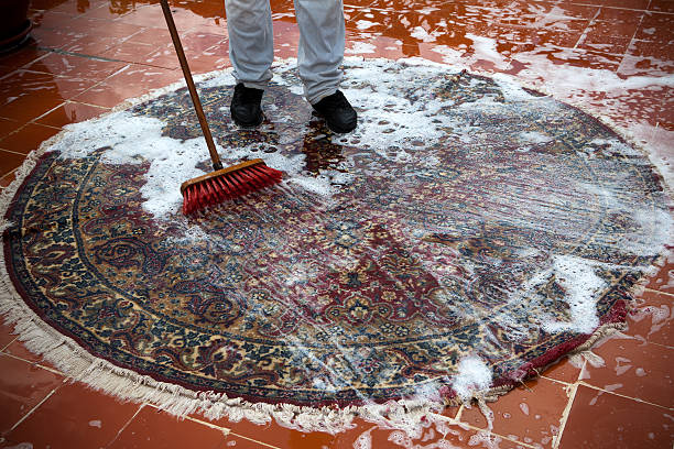 Washing rugs Man washing a rugs on the tile floor. rug stock pictures, royalty-free photos & images