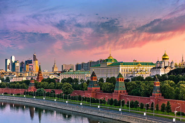 Cloudy sunrise over Kremlin wall and Moskva river View of the Moskva River along the Kremlin wall in Moscow, Russia, with water and a walkway in the foreground and a beautiful sunset sky in the background.  The image shows the Grand Kremlin Palace and the cathedrals of the Moscow Kremlin.  The view is from the top of the Hotel Baltschug Kempinski. kremlin stock pictures, royalty-free photos & images