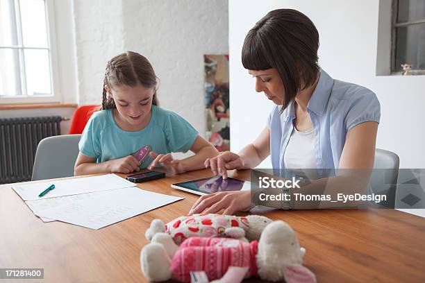Mother With Daughter Using Tablet And Cellphone Stock Photo - Download Image Now - Contemplation, Mother, Parent