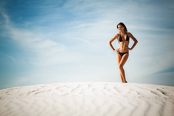 mulher posando na areia - young women sensuality sex symbol loneliness - fotografias e filmes do acervo