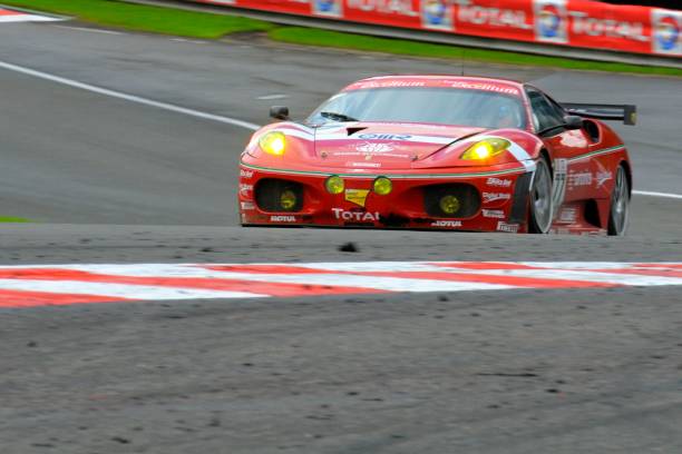 Ferrari F430 GT2 race car at the race track "Spa, Belgium - July 25, 2009: BMS Scuderia Italia Ferrari F430 GT2 driving through Eau Rouge during the 2009 24 hours of Spa Francorchamps GT1 race." ferrari ferrari f430 italian culture action stock pictures, royalty-free photos & images